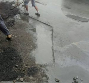 В Ужгороді комунальники засипали асфальт у ями з водою (ФОТО)